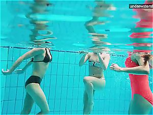 three nude dolls have fun underwater